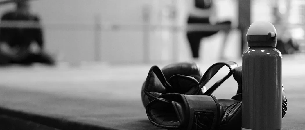 Gants de boxe et gourde posés au bord du ring